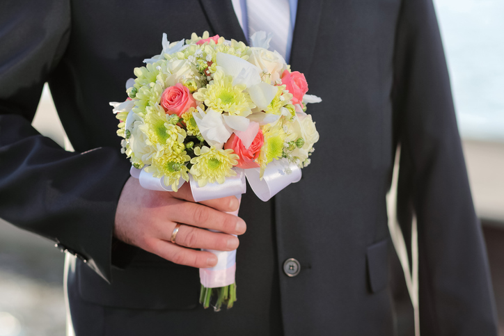 Wedding bouquet of rose in the hands of the groom